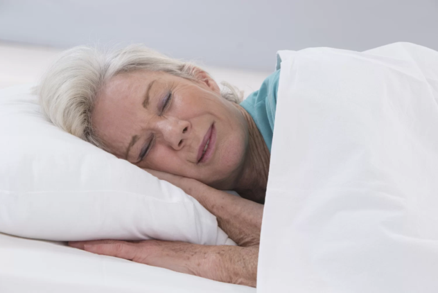 Persona mayor descansando en una cama